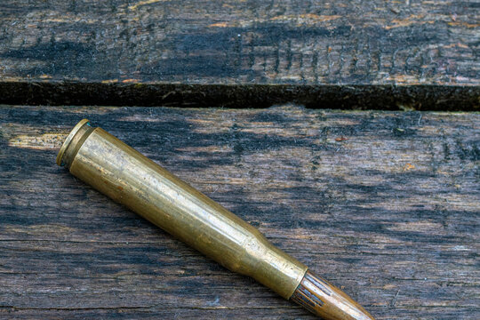 top view of big bullet on wooden background