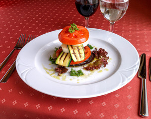 Vegetable tower of grilled eggplant and zucchini with cheese, tomato slices and lettuce