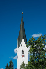 Fototapeta na wymiar Kirchturm der katholischen Kirche in Oberstdorf