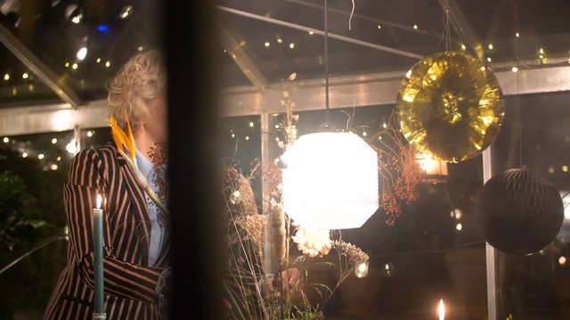Female decorating flowers in a greenhouse in christmas seeting.