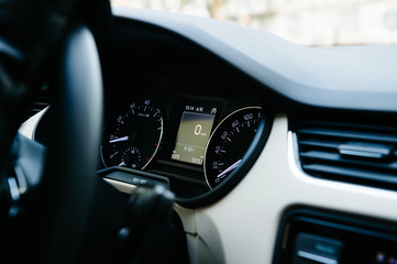 Fototapeta na wymiar Interior view of modern luxury car with analog and digital speed limit clock and zero kilometers on the digital dot matrix screen