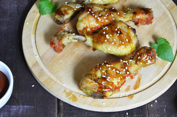Grilled spicy chicken legs on a black background.Top view. backet chicken on paper