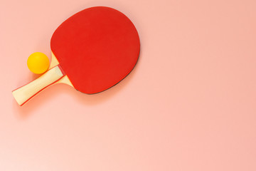 Red tennis ping pong racket isolated on a pink background, sport equipment for table tennis