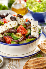 Traditional Greek salad consisting of fresh vegetables such as tomatoes, cucumbers, peppers, onions, oregano and olive oil, close up A delicious and healthy vegetarian, mediterranean dish
