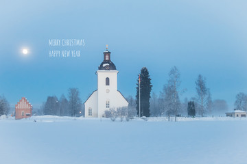 Christmas card with Christmas greetings and a winter landscape with the white church of the village Nås in the region Dalarna in Sweden 
