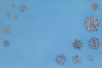 Christmas composition. Silver and golden snowflakes isolated on blue background. Copy space for your text.