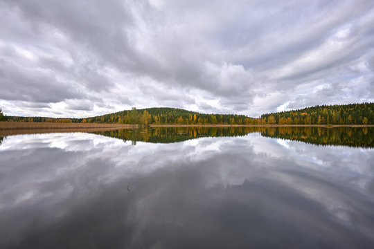 Incredible mirror-lake full of clouds, and forest in the background
