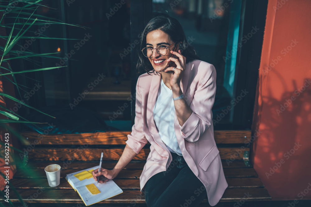 Poster portrait of cheerful georgian woman in stylish spectacles smiling at camera planning schedule while 