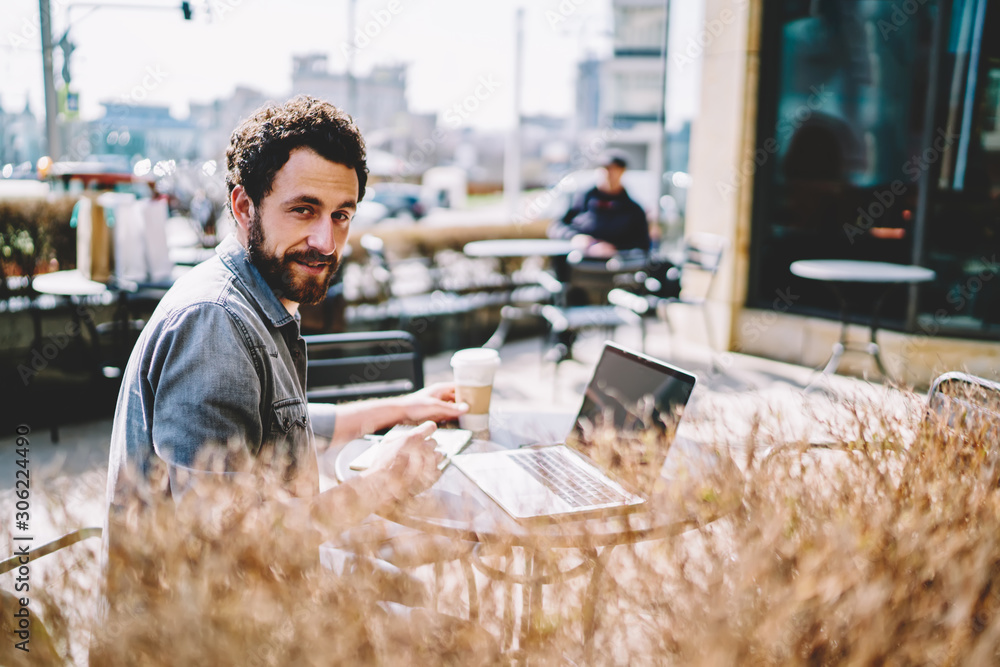 Poster portrait of bearded it developer dressed in casual wear looking at camera while working on developme