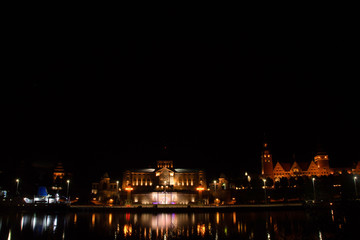 Fototapeta na wymiar Szczecin. Night view from across the river to the illuminated historic center. Odra river. Chrobry embankments in Szczecin