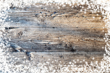 Naklejka premium Christmas wooden background with snow. View with copy space.