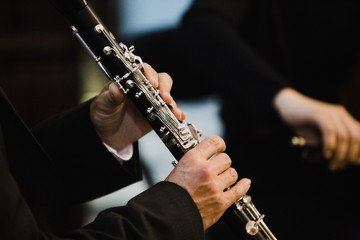 Obraz premium Clarinet player holding a metal transverse flute in his hands.