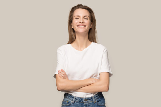 Happy smiling woman with arms crossed laughing at joke