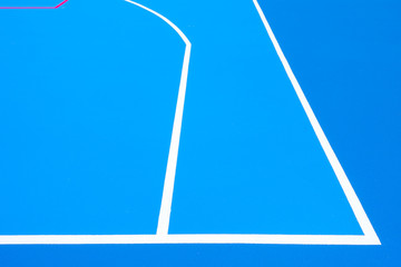 Intense blue background, from the floor of a basketball court to the midday sun, with straight lines and white curves.