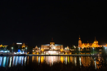 Fototapeta na wymiar Historic buildings at night. View across the Odra River in Szczecin