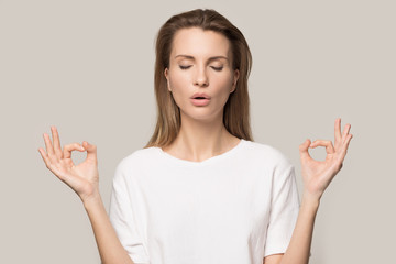 Calm woman relaxing, practicing yoga, meditating with closed eyes