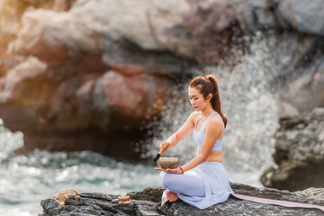 Beautiful Asian woman is practicing yoga meditation by tibetan singing bowl