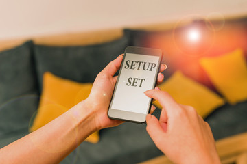 Word writing text Setup Set. Business photo showcasing the analysisner, position, or direction in which something is set woman using smartphone office supplies technological devices inside home