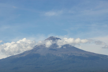 Fototapeta na wymiar Popocatepetl active volcano, blue sky
