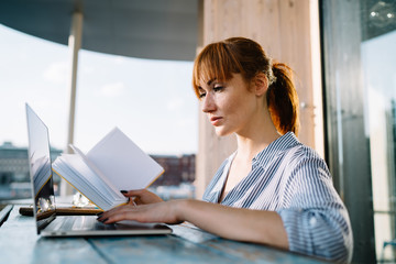 Side view of smart woman spending time for doing college homework in online regime researching information on university website for students, concept of e learning and knowledge education