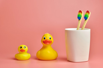 Two toothbrush and bathroom duck toys. LGBT personal care concept. Protect oral cavity, remove...