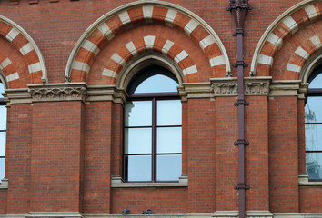 red brick facade of historic building with arched windows