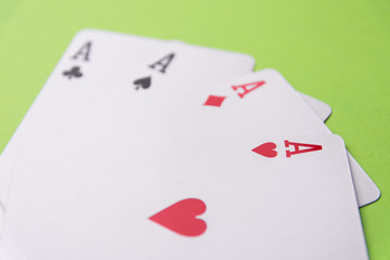 Four aces on green background. Concept of gambling risk. From above. Copy space