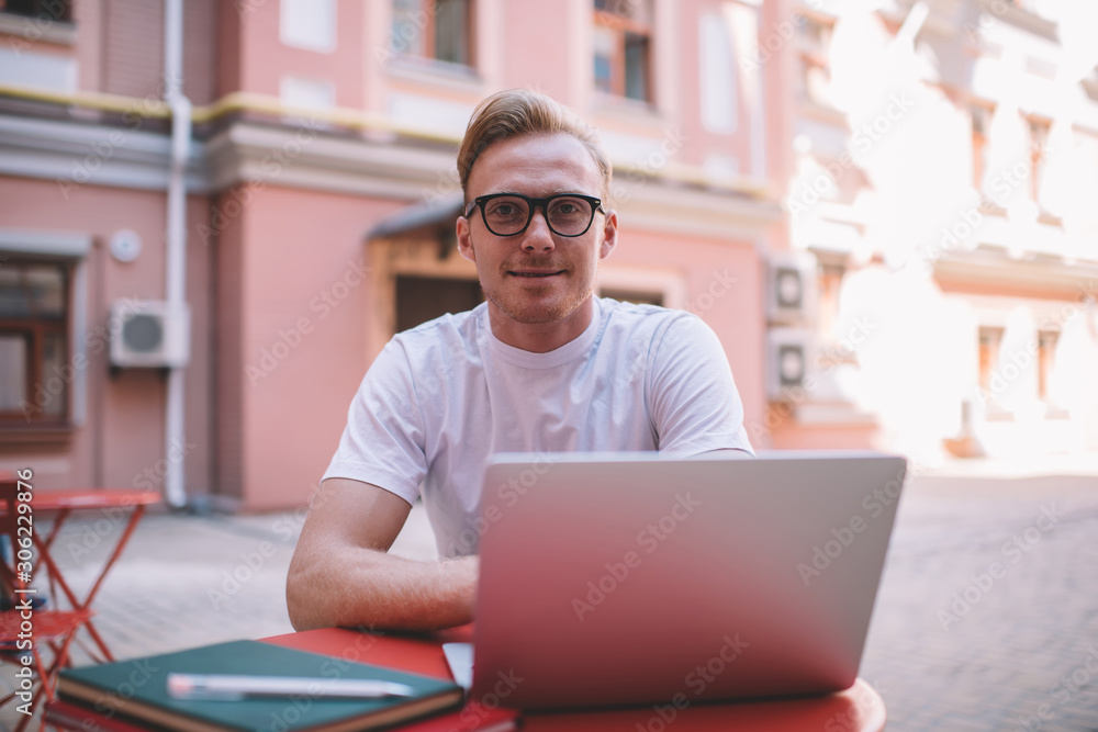 Aufkleber portrait of skilled male it professional in stylish eyewear looking at camera during break from onli