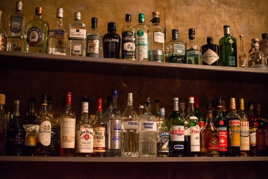 Bar shelves full of alcoholic beverages bottles