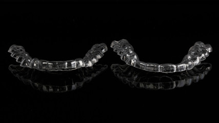 two dental individual mouthguards on a black background