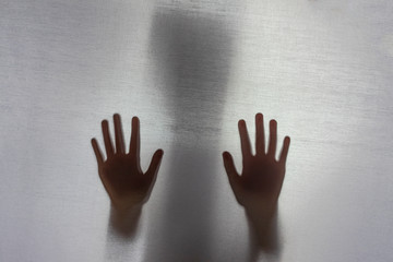 no focus. the fabric behind her. silhouette and shadow. child with his hand against the fabric, please help. domestic violence concept. - obrazy, fototapety, plakaty