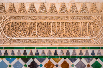 Finely decorated walls in the Alhambra Palace in Granada with arabic inscriptions. Andalusia, Spain. June-03-2019