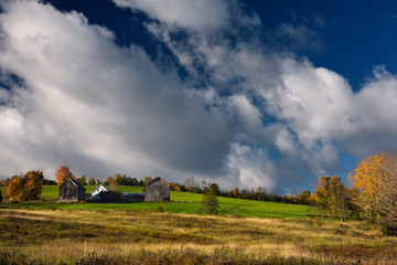 Obraz premium Farmhouse and barns at sunrise on hillside West Burnet Vermont in the Fall