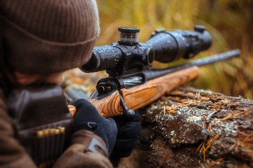 a rifle with a telescopic sight. hunting in the forest - obrazy, fototapety, plakaty