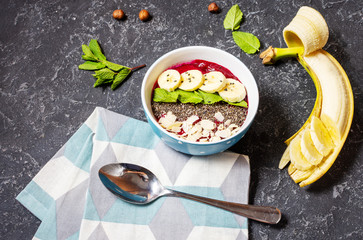 Healthy breakfast bowl - blueberry smoothie with banana, raspberry, almonds and chia seeds.
