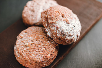 Homemade delicious chocolate cookies with powdered sugar on dark background