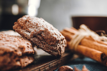 Homemade bakery, chocolate cookies with powdered sugar, cinnamon sticks, close-up view