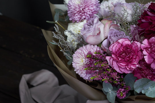 Pink and purple toned bouquet in vintage style on a dark background, selective focus