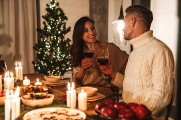 Photo of happy family couple smiling while having Christmas dinner