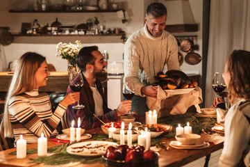 Photo of caucasian excited people having Christmas dinner with turkey