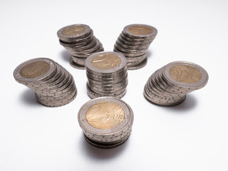 Curious background of six columns built by two euro coins on white background