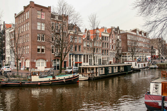 Amsterdad Canal, with boats and houses on both sides of the river and houses around © Fernando