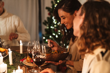 Photo of caucasian joyful people eating while having Christmas dinner