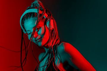 Dj woman with tree braid hair and dancing with headphones.