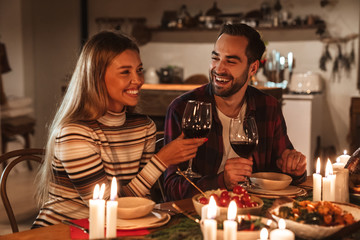 Photo of excited cute couple having Christmas dinner