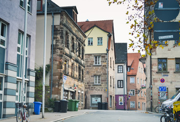 Fototapeta na wymiar Furth, Germany, 21 November 2019: view of one of the city streets. 19th century houses with multi-colored facades. Bicycle parking. Garbage bins.