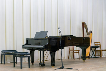Black grand piano on a wooden stage
