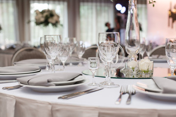 round served feast table with plates, glass, fork and knife. festive table in the restaurant on the birthday on wedding party. Number at banquet  table for guests  in the restaurant