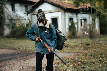 Naklejka premium woman with gas mask, backpack and double barrel shotgun. post-apocalyptic, military and airsoft war games concept.