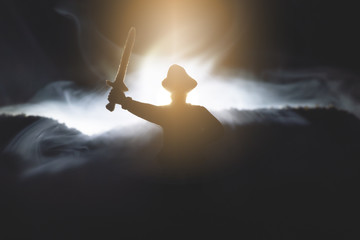 The pirate captain in the hat with raised up swords in the night fog concept.